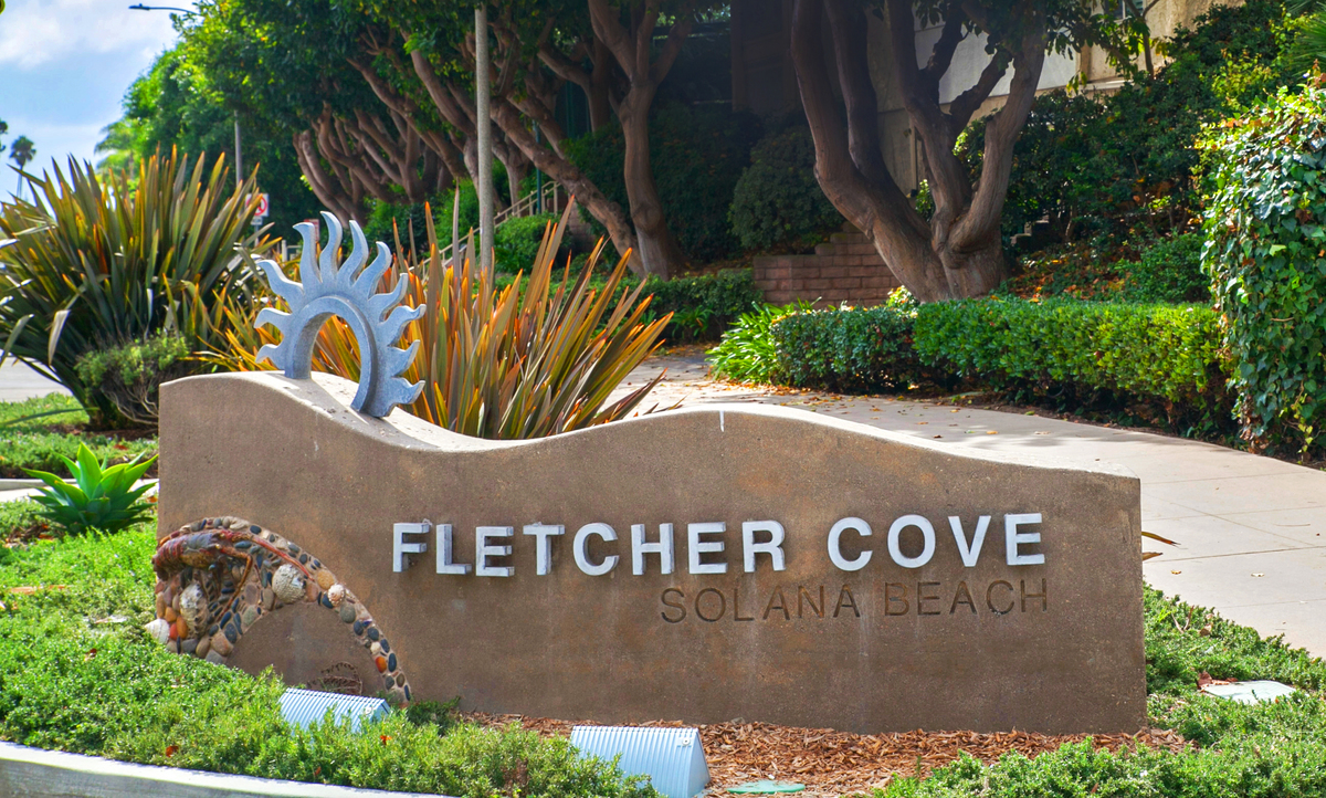 sign that reads "Fletcher Cove" surrounded by grass