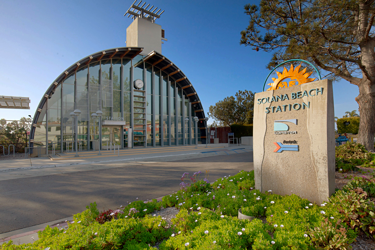 sign that read "Solana Beach Station" in front of a building that is the train station